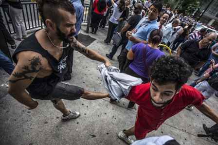 O publicitário Vinícius Vasconcellos sendo agredido por manifestantes pró-impeachment. Foto: Felipe Larozza/VICE