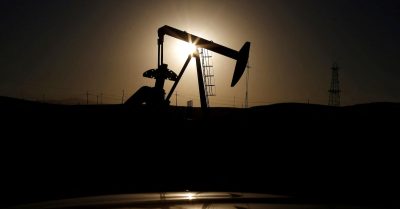 Bomba de extração de petróleo em silhueta contra o pôr do sol