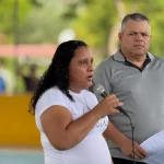 Mulher discursa com microfone em evento na Comuna Socialista Agropesquera «Virgen de Coromoto», Macanao, Nueva Esparta. (Foto