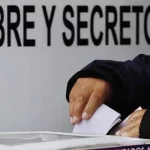 Um eleitor deposita voto em urna com placa "LIBRE Y SECRETO" ao fundo. (Foto: regeneracion.mx)