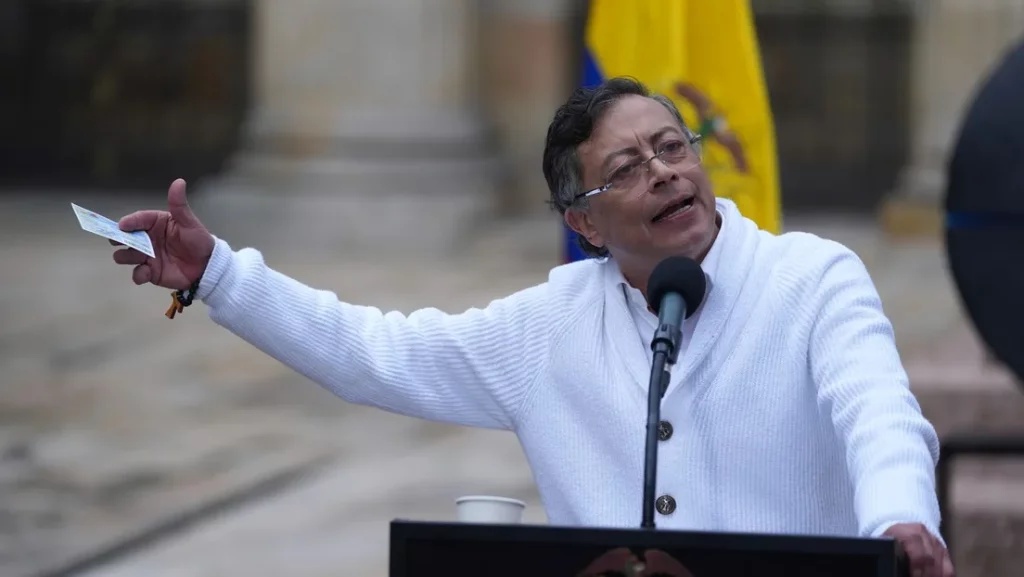 O presidente colombiano Gustavo Petro discursa em evento público, com bandeira nacional ao fundo. (Foto: actualidad.rt.com)
