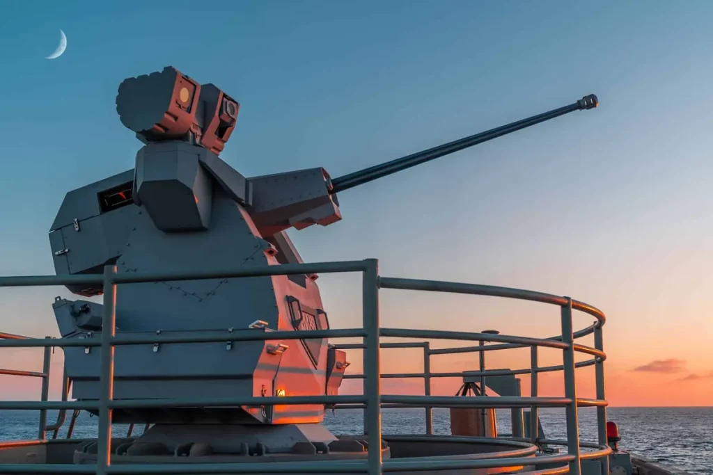 Sistema de arma remota instalado em navio militar ao entardecer. (Foto: navalnews.com)