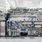 Máquinas avançadas de fabricação de chips em operação dentro de uma fábrica. (Foto: technologyreview.com)