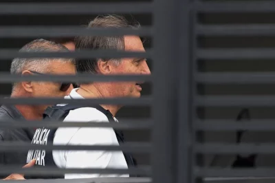 O ex-presidente Jair Bolsonaro é visto em trânsito, acompanhado por um agente da Polícia Militar. (Foto: g1.globo.com)