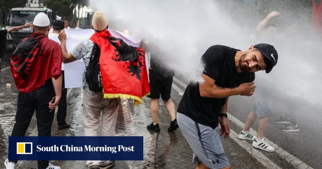 Protestos intensos contra projeto de resort ligado à família Trump na Albânia, com manifestantes enfrentando jatos d'água da
