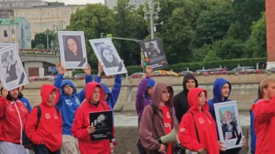 Manifestantes em Moscou seguram retratos durante protesto contra o Reino Unido, acusado de ser "patrocinador do terror". (Fot