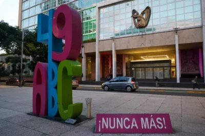 Escultura com as letras "49 ABC" e placa que diz "¡NUNCA MÁS!" em frente a edifício, em referência ao caso Guardería ABC. (Fo