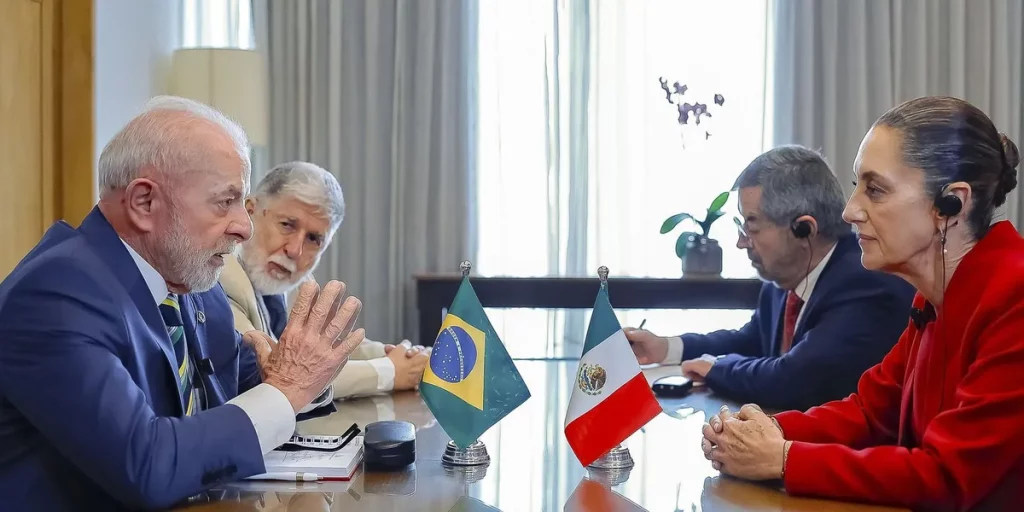 Presidente Lula participa de reunião com autoridades mexicanas, com bandeiras do Brasil e México à mesa. (Foto: agenciabrasil