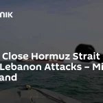 Um navio mercante navega no Estreito de Hormuz, com silhueta de pessoa em primeiro plano. (Foto: sputnikglobe.com)