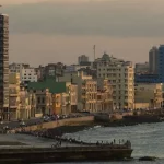 Vista da orla de Havana, com edifícios e pessoas ao longo do cais. (Foto: telesurtv.net)