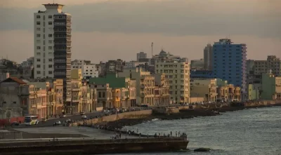 Vista da orla de Havana, com edifícios e pessoas ao longo do cais. (Foto: telesurtv.net)