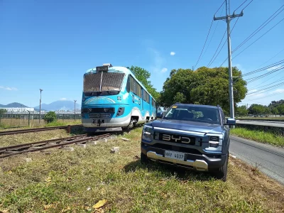 Um veículo elétrico híbrido da BYD e um trem híbrido estão estacionados lado a lado em uma área ao ar livre. (Foto: cleantech