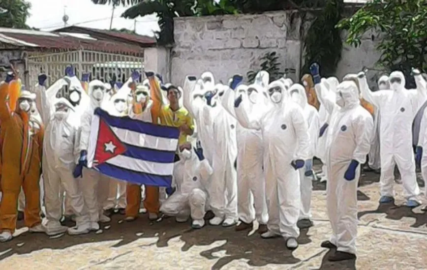 Trabalhadores em trajes de proteção com a bandeira de Cuba durante operação contra o vírus Ebola. (Foto: nodal.am)