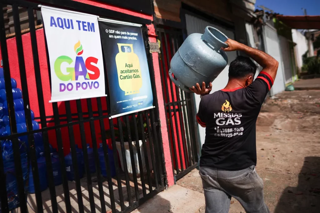 Homem carrega cilindro de gás em frente a loja que vende "Gás do Povo". (Foto: WWW1.FOLHA.UOL.COM.BR)