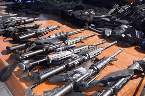 Armas de fogo apreendidas dispostas sobre uma mesa. (Foto: jornada.com.mx)