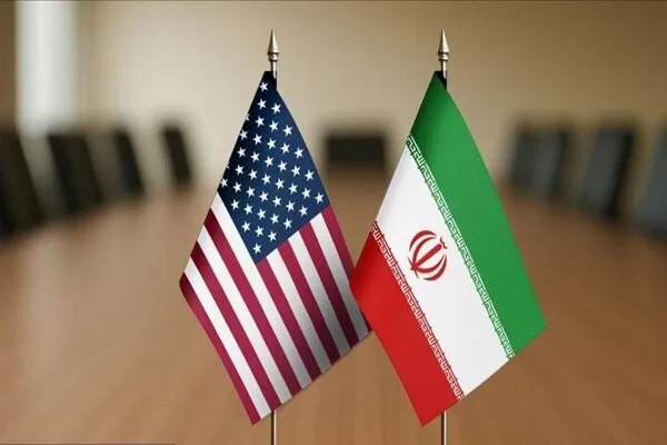 Bandeiras dos Estados Unidos e Irã dispostas em mesa de reunião. (Foto: en.mehrnews.com)