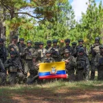 Militares equatorianos posam com a bandeira nacional em treinamento ao ar livre. (Foto: actualidad.rt.com)