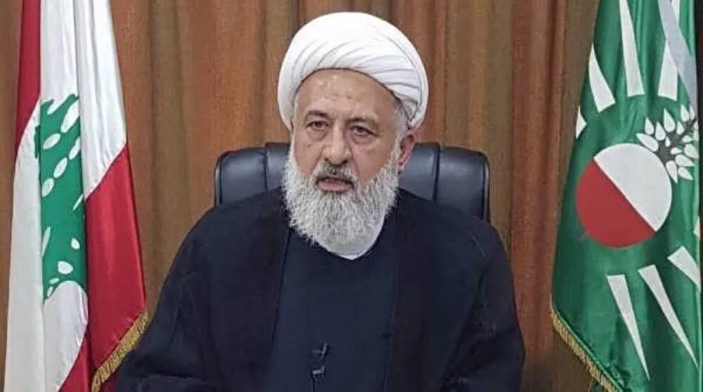 Sheikh Ali al-Khatib, com as bandeiras do Líbano e de um partido político ao fundo. (Foto: en.mehrnews.com)