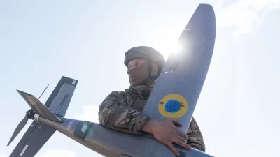 Soldado segura drone militar sob sol brilhante. (Foto: rt.com)