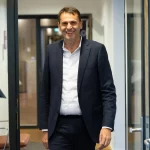 Executivo da ASML é visto sorrindo em corredor de escritório. (Foto: techcrunch.com)