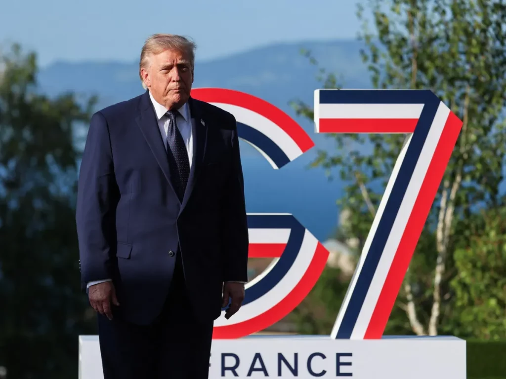 Presidente Donald Trump posa em frente ao símbolo do G7 durante evento na França. (Foto: aljazeera.com)