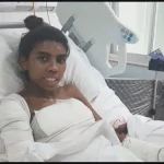 Mulher ferida em acidente é vista em leito hospitalar com bandagens no braço e no corpo. (Foto: g1.globo.com)