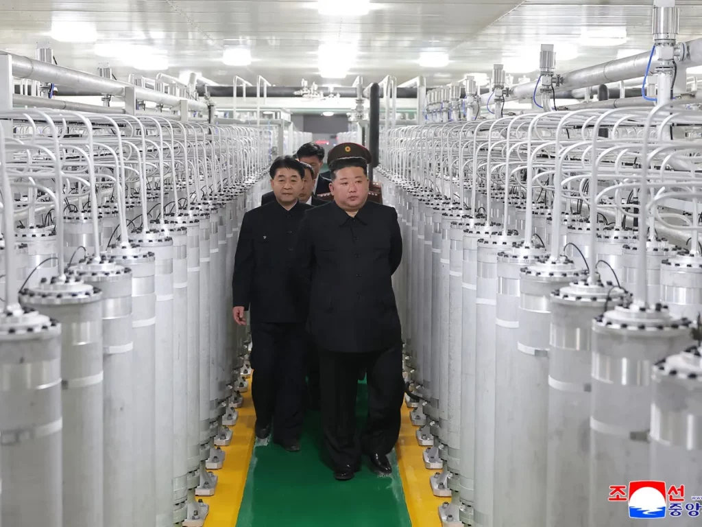 Kim Jong Un inspeciona instalação industrial com tanques cilíndricos, acompanhado por oficiais. (Foto: aljazeera.com)